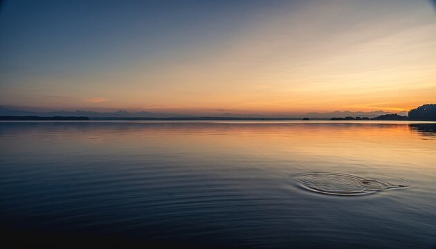 Calm Ocean Reflecting Golden Sunset Sky with Distant City Skyline and Gentle Waves on Sandy Shore