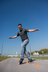 A Caucasian man rollerblades around the slalom course.