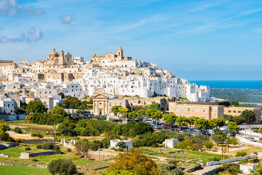 Panoramic view of the whitewashed hilltop town of Ostuni, known as the &ldquo;White City,&rdquo; with its cathedral and sea views in the background, Apulia, Italy