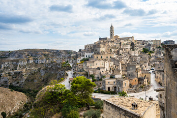 Fototapeta premium Majestic view of Matera’s hilltop old town blending into the rugged canyon landscape. Apulia, Italy