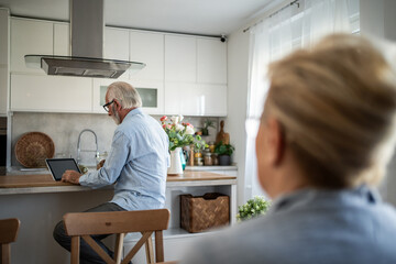 Senior man using digital tablet in modern kitchen