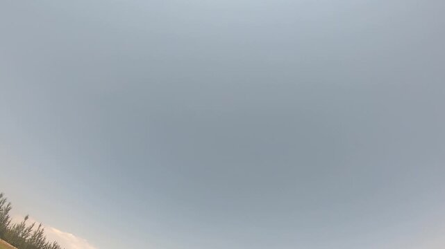 Action camera POV of a sportsman loading and firing a shotgun at a shooting range. The footage captures the weapon recoil against a clear blue sky and mountains.

