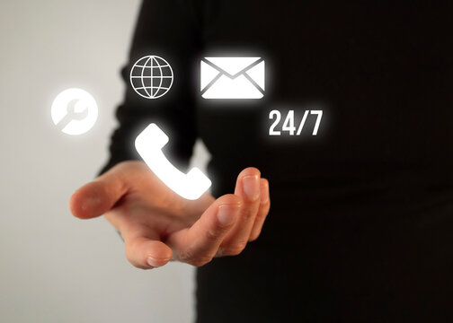 24/7 technical support phone number. A hand holds a phone. The hand also holds a globe, an envelope, and a tool.