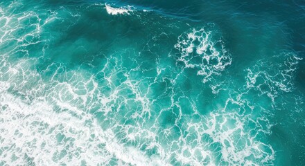 Overhead shot of churning ocean waves in varying shades of teal and turquoise, creating a textured and dynamic surface