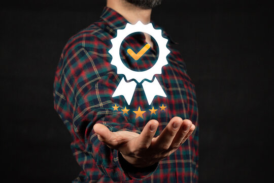 a right hand of a man holding a corporate quality warranty five star excellence seal