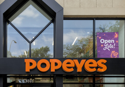 Popeyes restaurant sign above entrance to fast food fried chicken restaurant in Greenwhich Village Manhattan New York City USA.