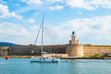 Sailboat on sea and lighthouse of old historic Agia Mavra castle, Lefkada island, Greece