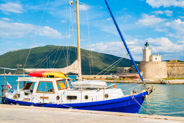 Sailboat on shore and lighthouse of old historic Agia Mavra castle, Lefkada island, Greece