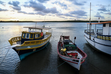 Fototapeta premium fishing boats moored at potengi river, natal brazil, sunset light on water traditional brazilian fishing vessel, coastal life and maritime culture small and large boats at low tide