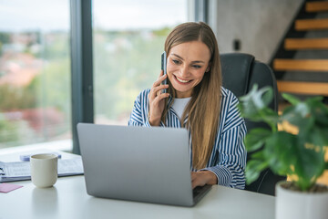 Woman working from home office making a phone call