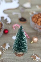 Various Christmas decorations, cookies, chocolate and nuts on wooden background. Selective focus.