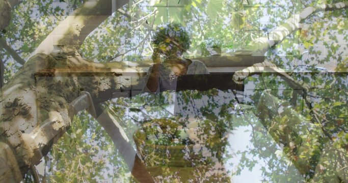 Sitting senior African American woman touching face at piano by window, with tree canopy overlay