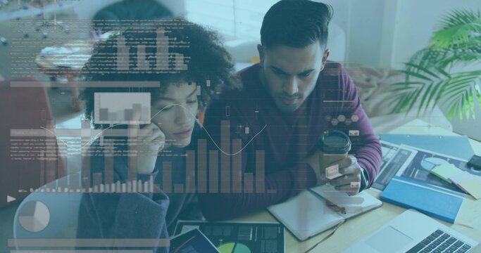 Analyzing two coworkers in dark sweater and maroon sweater at home workspace, viewing laptop charts - Powered by Adobe