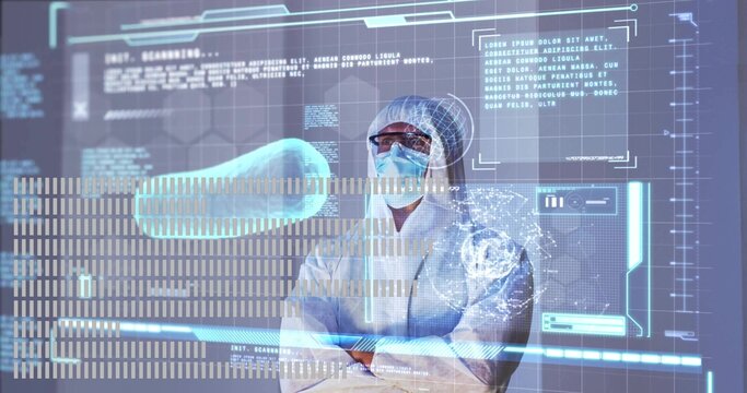 Monitoring researcher in hooded suit, goggles, gloves in cleanroom, viewing HUD capsule and brain