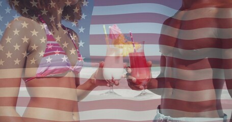 Toasting couple holding cocktails at shore wearing pink bikini swim trunks American flag overlay