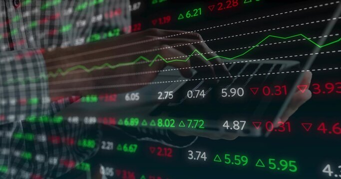 Tapping plaid-shirted man manipulating tablet at workspace, with glowing stock market graphics