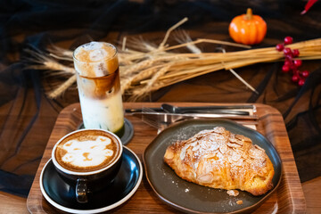 Close up delicious breakfast menu croissant and coffee cup on the wood table in the restaurant.