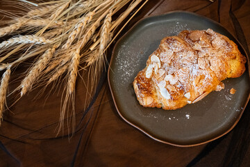 Close up delicious breakfast menu croissant and coffee cup on the wood table in the restaurant.