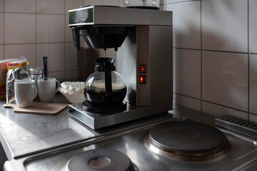 Sleek coffee brewing system with glass carafe positioned on modern kitchen counter