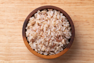 Cooked Thai brown rice in a wooden bowl, Table top view, Healthy eating