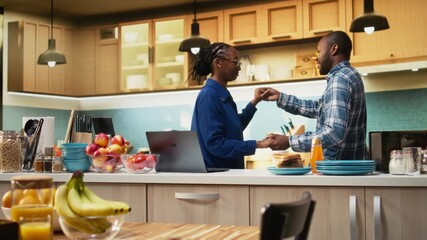Romantic young black couple sharing a cute dance in the kitchen, starting the morning with affectionate sweet moment and love song. Slow dancing and holding hands, intimate connection. Camera A.
