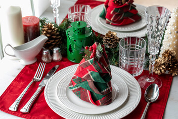 A holiday table setting with a folded napkin in the shape of a tree.