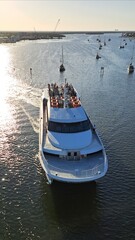 Passenger Ferry in Morning Light with Boats and Coastal Skyline.