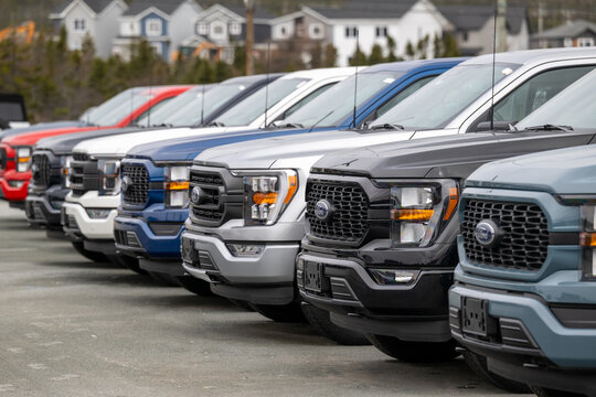 St. John's, Newfoundland, Canada-December 1, 2025: A row of Ford F-150 pickup trucks. Both gasoline and electric, the new vehicles are parked in a dealership parking lot in a row on lot for sale. 