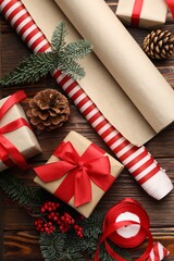 Festive packaging. Gift boxes, ribbon, wrapping paper and Christmas decor on wooden table, flat lay