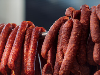Fototapeta premium Cured Sausages Hanging to Dry in Charcuterie