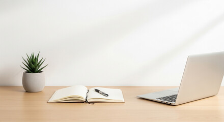 Bright workspace with laptop, notebook and succulent on wooden desk indoors