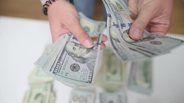 offering cash for transaction, close view of hands presenting assorted banknotes for exchange or gratuity, detailed shot of hands extending variety of bills for payment or tip purposes
