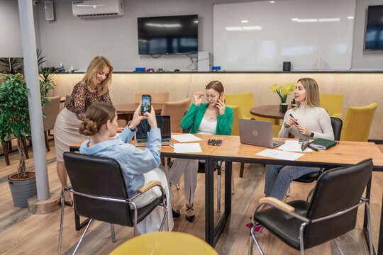 Business teamwork meeting, women collaborating in a modern office taking a photo and making a phone call