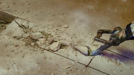 Demolishing concrete with a Jack hammer in residential construction for plumbing drains. 