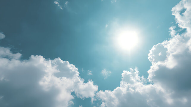 Bright sun shining through fluffy clouds in a clear blue sky, creating a serene and uplifting atmosphere.