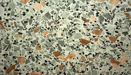 A close-up of a light marble mosaic with multicolored small-grain inclusions.