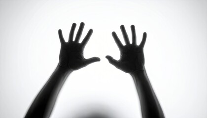 Two hands reaching up, shadowed against a bright background