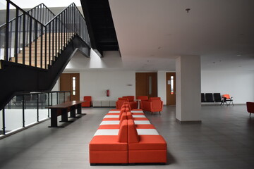 indoor space with orange and white benches and stairs