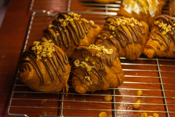 Close up photo of tray of golden brown, flaky and look freshly baked croissants in bakery.