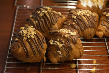 Close up photo of tray of golden brown, flaky and look freshly baked croissants in bakery.