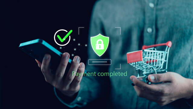 A person holding a smartphone and shopping cart with glowing security icons, representing safe mobile payment, digital transaction completion, e-commerce security, and online financial trust.