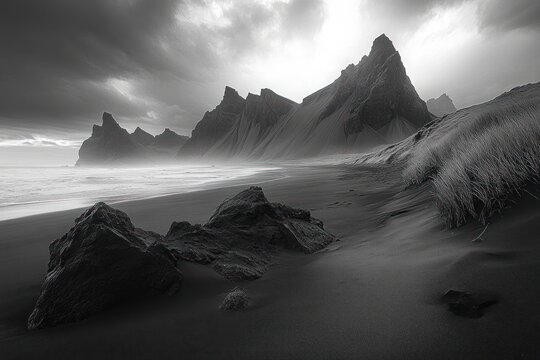 Haunting moody black sand beach with jagged sea cliffs, scattered boulders, windswept dune grass and misty surf beneath a dramatic cloudy sky