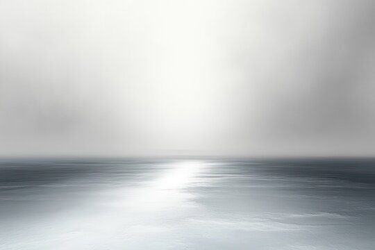 foggy seascape with calm reflective water, soft horizon glow and empty sky conveying serene peaceful solitude
