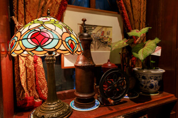 レトロカフェのステンドグラスランプとコーヒーミルが並ぶアンティークなインテリア

