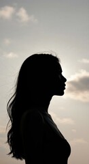 Silhouette of Reflection: A striking silhouette of a woman emerges against a softly lit sky, creating a tranquil scene of introspection and inner peace. This image embodies calm.