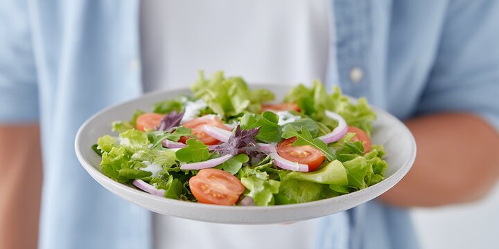 Person is holding a plate of salad