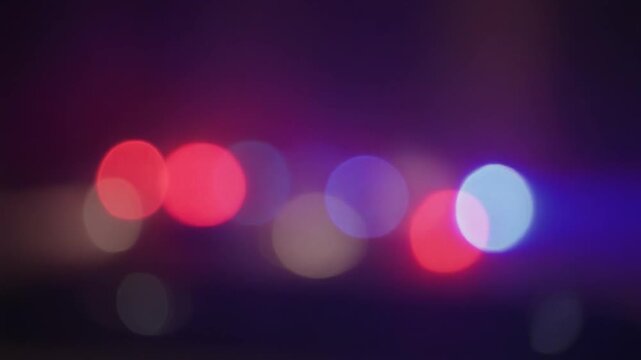 Dynamic blurry footage (bokeh) of red and blue emergency lights flashing at night, creating a tense and urgent atmosphere.&nbsp;Ideal for projects related to emergency services, pd