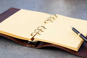 Opened schedule planner, diary, notebook on table
