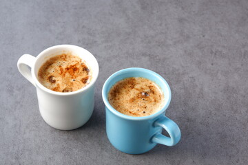 Two cups of café au lait,“coffee with milk” in French on white table
