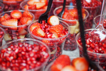 Fresh fruit cups with strawberries and pomegranate seeds